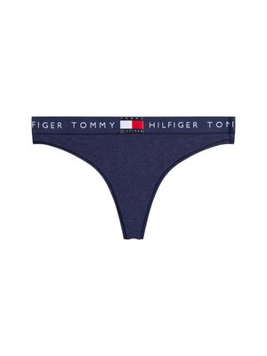 Navy zils tanga apakšbikses, izgatavotas no mīkstas auduma, ar platu jostu, uz kuras ir balts "TOMMY HILFIGER" logo un kontrastējošas krāsas akcenti.