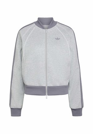 Veste zippée Adidas gris clair avec col, poignets et bas côtelés, avec des bandes gris foncé sur les manches et logo Adidas sur la poitrine.