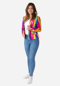 Colorful tailored blazer with vertical stripes in pink, yellow, and blue, paired with fitted jeans and white sneakers. Smooth texture.