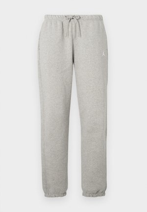 Hellegraue Jogginghose mit elastischem Bund, Kordelzug, seitlichen Taschen, umgeschlagenen Knöcheln und kleinem weißen Logo am Oberschenkel.