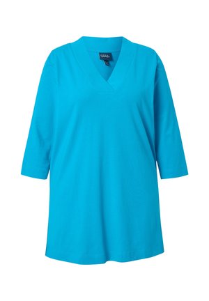 Kirkkaan sininen tunika V-kaula-aukolla ja kolmen neljänneksen hihoilla, väljä istuvuus, esitetty valkoista taustaa vasten.