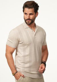 Beige Poloshirt mit kurzen Ärmeln, gestrickten vertikalen Streifen, einer Drei-Knopfleiste, gerippten Bündchen und einer glatten Textur.