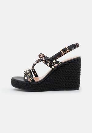 Sort kile sandal med flettet platform, leopardprint stropper, guldnitter og justerbar guldbeslået ankelrem.
