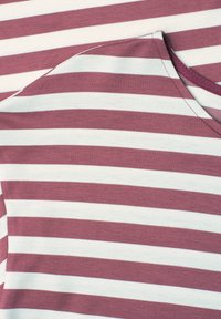 Foldet stof med vandrette bordeaux og hvide striber, der viser en buet søm og stingdetaljer.