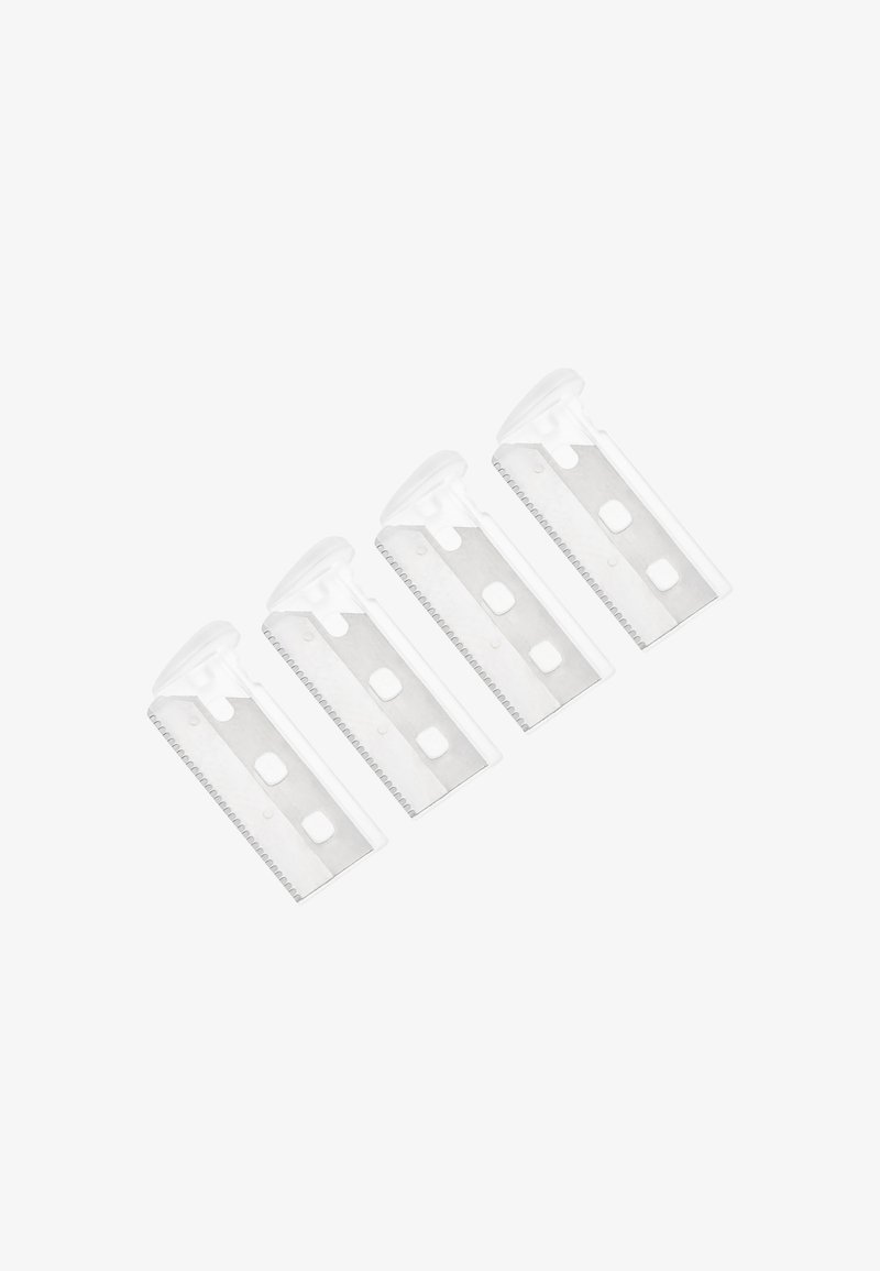 Quatre capuchons transparents en plastique pour lames de rasoir de sécurité disposés en diagonale sur un fond blanc.