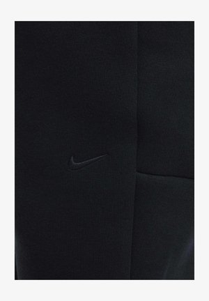 Mustat Nike-housut, joissa on ribbineulottu rakenne, istuva malli ja näyttävä vasemmalla puolella brodeerattu logo.