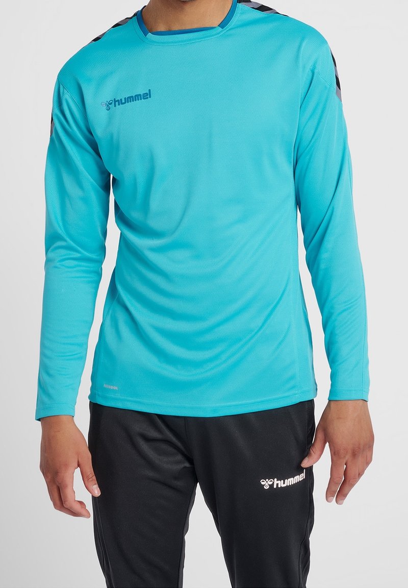 Langärmliges Sportshirt in leuchtendem Türkis, mit Stofftextur, rundem Ausschnitt und schwarzen gemusterten Akzenten auf den Schultern.