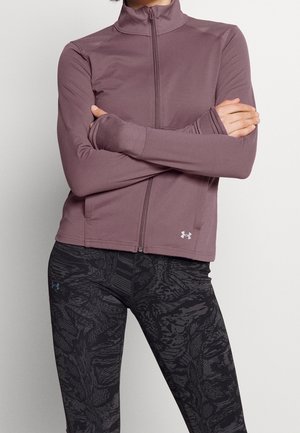 Veste zippée violet clair avec un col montant, des manches longues et des trous pour les pouces. Assortie à un legging noir avec un motif abstrait texturé.