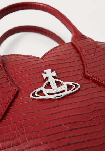 Borsa a tracolla rossa con texture, dotata di due manici e un emblema a sfera argentata lucida con una croce sul davanti.