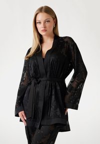 Czarny przezroczysty szlafrok w stylu kimono z kwiatowymi wzorami, szerokimi rękawami i zawiązywanym paskiem w talii. Gładki materiał z kontrastowymi satynowymi wykończeniami.