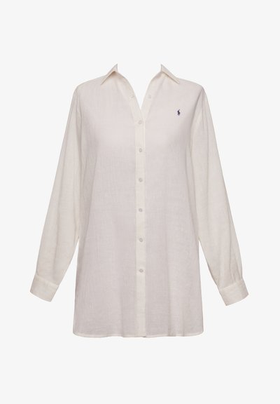 Λευκό λινό πουκάμισο με κουμπιά, μακριά μανίκια, κλασικό γιακά και ένα κεντημένο λογότυπο στο στήθος. Μαλακή υφή, άνετη εφαρμογή.