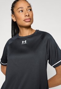 Black athletic t-shirt with short sleeves, made from a breathable fabric, featuring a white logo and trim along the sleeves.