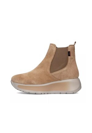 Stivale alla caviglia in suede beige con linguetta, pannello laterale elasticizzato e robusta suola in gomma beige, mostrato in profilo rivolto a sinistra.