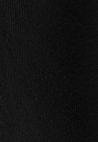 Tessuto lavorato a maglia nero, caratterizzato da una superficie testurizzata con un motivo a coste diagonali, morbido e flessibile per garantire resistenza e durabilità.