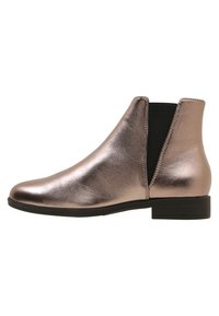 Metallinen ruusukultainen nilkkuri, jossa on joustavat sivupaneelit, pyöreä kärki, matala paksukantalappu ja sileä pintakuvio. Yksinkertainen muotoilu ilman koristeita.