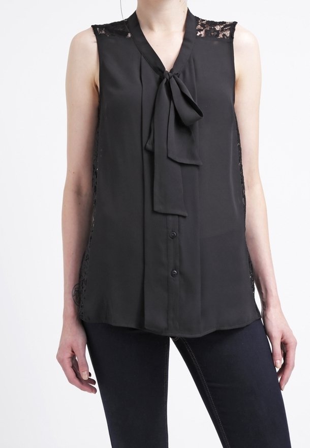 Blouse sans manches noire avec des détails en dentelle aux épaules, fermeture à boutons à l'avant et un nœud attaché au cou. Tissu léger et lisse.