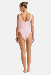 Rosa enstaka baddräkt med djup rygg, breda axelremmar och slät textur. Har en figurnära design och måttlig skärning på benen.