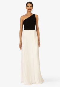 Abendkleid mit einem Schulterträger, einer enganliegenden schwarzen strukturierten Korsage und einem fließenden weißen Rock. Glattes Material mit klaren Linien und minimalen Akzenten.