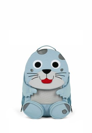 Light blue children's backpack shaped like a smiling seal with big eyes, whiskers, and flipper-shaped pockets at the front.