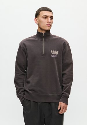 Dark gray zip-up sweatshirt with a high collar, featuring a logo on the left chest and ribbed cuffs and hem. Smooth, soft fabric.
