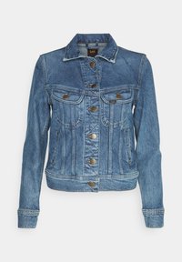Veste en denim bleu clair avec une fermeture à boutons, deux poches poitrine et un col classique. Présente un tissu texturé et des détails d'usure naturelle.