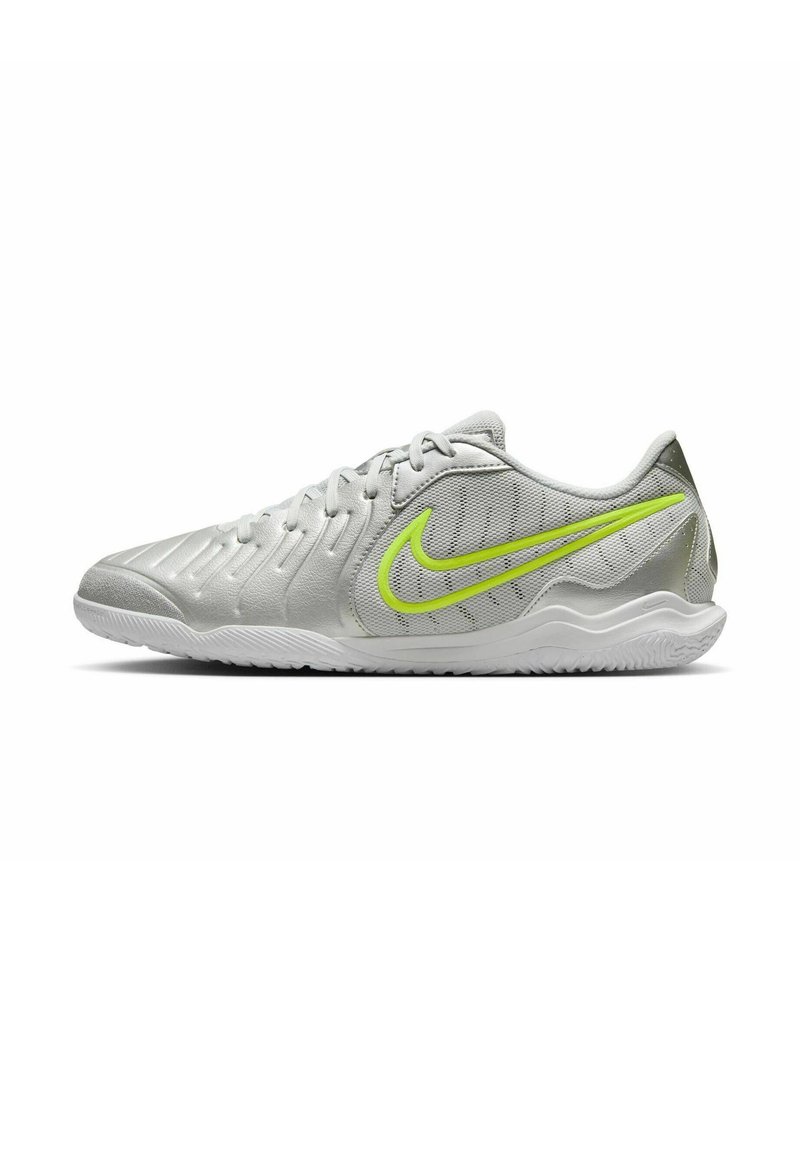 Sport shoes in light gray with textured upper and green Nike swoosh. Features curved design, lace-up closure, and rubber sole.
