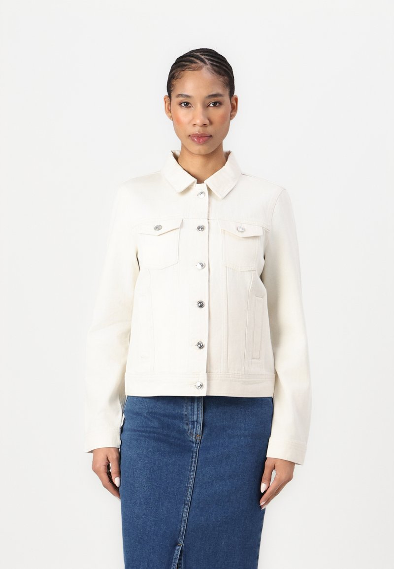 Hvit denimjakke med lange ermer, krage, frontlommer, sølvknapplukking, og en tettsittende design. Båret over et blått denimskjørt.