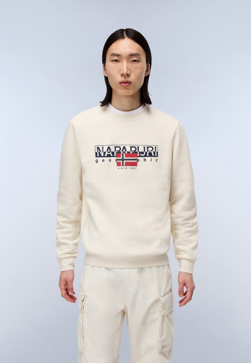 Crèmekleurige sweatshirt met een ronde hals, voorzien van een grafische logo met de Noorse vlag. Gecombineerd met bijpassende crèmekleurige cargo-broeken.