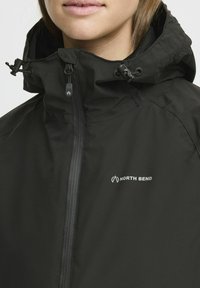 Black waterproof jacket with a zip front, adjustable hood, and elastic drawstring. Features "NORTH BEND" logo on the right side. Textured fabric.