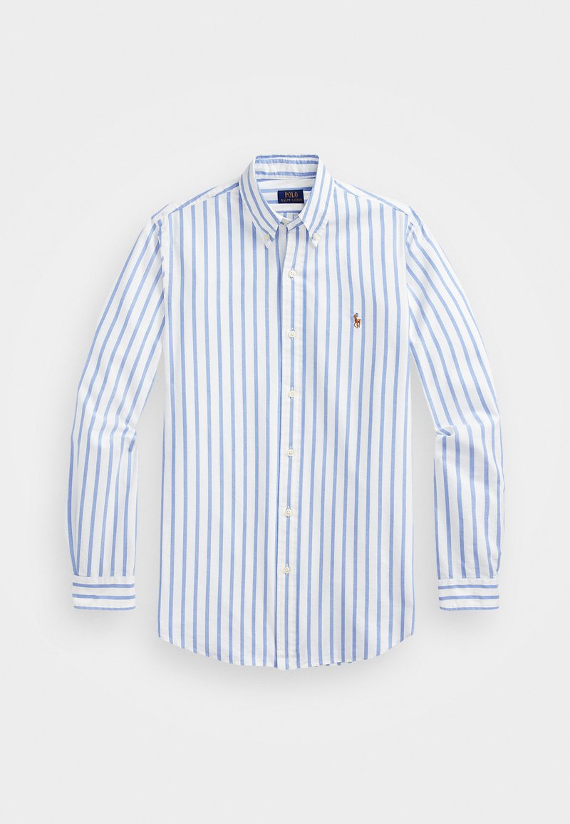 Camicia bianca con righe blu sottili, dotata di colletto, maniche lunghe e un piccolo logo sul petto. Tessuto di cotone morbido.