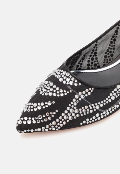 Pantofii din material textil negru au vârful ascuțit, fiind împodobiți cu strasuri argintii dispuse în pattern-uri spirale, având, de asemenea, o căptușeală interioară texturată.