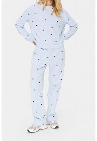 Set composto da felpa e pantaloni azzurro chiaro con piccoli motivi a cuore neri. Tessuto morbido, polsini e vita elasticizzati. Vestibilità casual e design confortevole.