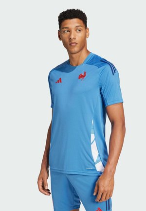 Blå sportsjersey lavet af letvægtsmateriale. Har rød logo og accenter, med et moderne design og kontrastsidepanel. Korte ærmer.