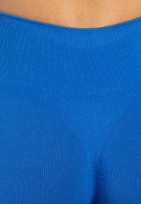 Vibrant blauw sporttop met een ribbelige tailleband en een soepele textuur, ontworpen voor comfort met een aansluitende pasvorm.