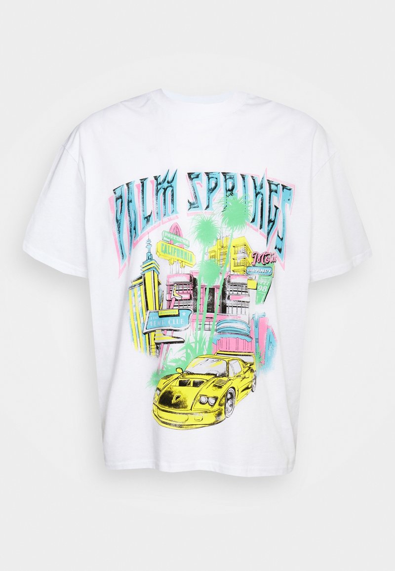 T-shirt blanc avec un graphisme coloré d'une voiture de sport jaune, des palmiers, des bâtiments et des panneaux de rue de Californie, avec un texte stylisé au-dessus.