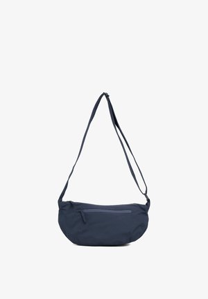 Torba za čez rame iz temno mornarsko modre tkanine, ki ima ukrivljeno obliko, nastavljiv pas in sprednji žep z zadrgo za varno shranjevanje.