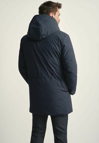 Ciemnoniebieska kurtka puchowa z kapturem, charakteryzująca się gładką teksturą i dopasowanym krojem. Regulowany sznurek w pasie zapewniający idealne dopasowanie.
