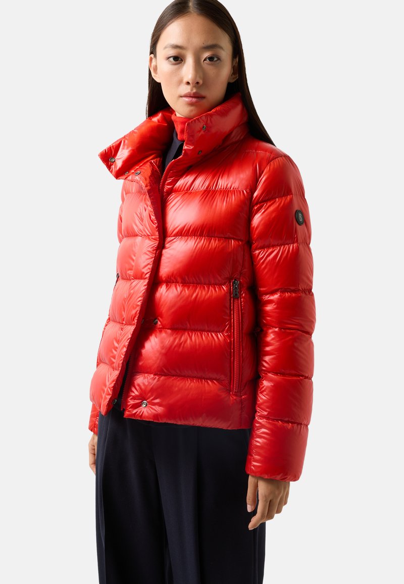 Veste rouge gonflante avec un col haut, des poches latérales zippées et une finition brillante. Dotée d'un logo sur le bras gauche.