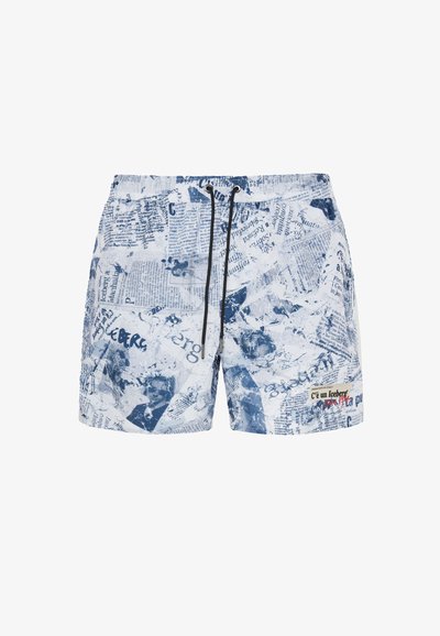 Pantaloni da bagno blu e bianchi con un design ispirato ai giornali, vita con cordino e tasche laterali. Il materiale sembra leggero e testurizzato.