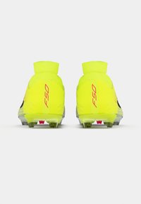 Φωτεινά κίτρινα ποδοσφαιρικά παπούτσια με κομψό σχέδιο, που διαθέτουν ψηλό αστράγαλο, υφασμάτινη επιφάνεια, μαύρες λεπτομέρειες και διαφανείς καρφίτσες.