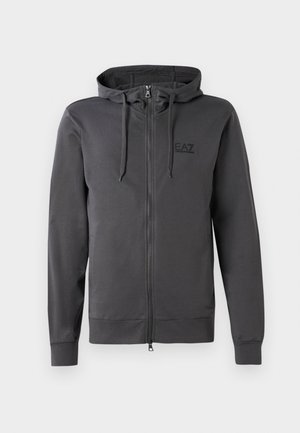 Grå hettegenser med glidelås laget av mykt materiale, med en frontglidelås, justerbar hette med snorer, og en liten svart logo på brystet.