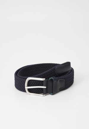 Ceinture en tissu tressé bleu marine avec une boucle en métal argenté. Elle présente un accent en cuir près de la boucle et un tissage texturé sur toute sa longueur.