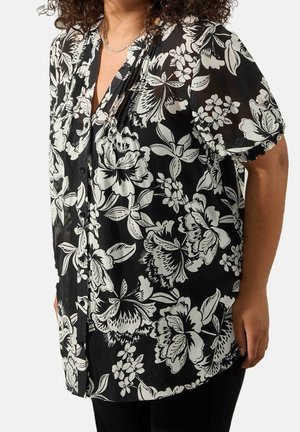 Schwarzes transparentes Hemd mit weißen Blumenmustern, durchgehender Knopfleiste, kurzen gerafften Ärmeln und fließender Silhouette.