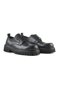 Scarpe in pelle nera con lacci, punta arrotondata, suola in gomma spessa e motivo di battistrada testurizzato. Presentano un'etichetta sul tallone.