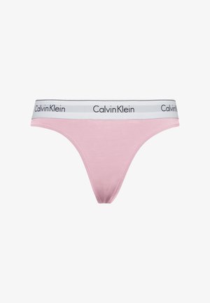 String en coton rose avec une taille blanche arbōrant le logo "Calvin Klein" en noir. Texture lisse, design minimaliste et coupe ajustée.