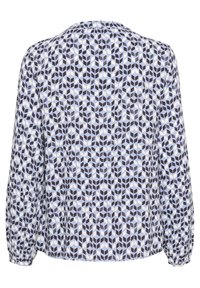 Blusa a maniche lunghe in tessuto blu chiaro con un motivo geometrico di forme blu scuro e bianche, con polsini arricciati e scollatura rotonda.