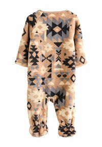 Fleece jumpsuit med en tan baggrund, prydet med geometriske mønstre i sort, grå og creme. Langærmede og med elastiske ankler.
