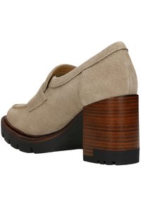 Beige suède schoen met een ronde neus, een uitsnede en een robuuste houten hak. De zool is tekstuur voor grip.