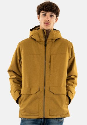 Chaqueta amarilla-marrón con capucha, cierre de cremallera en el frontal, dos grandes bolsillos delanteros y una tela texturizada. Diseño minimalista con líneas limpias.