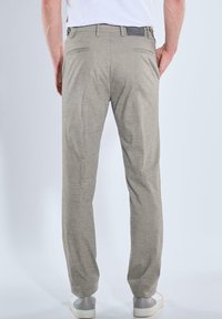 Light gray trousers made of woven fabric, featuring a straight cut, two back pockets, and a small logo patch on the waistband.